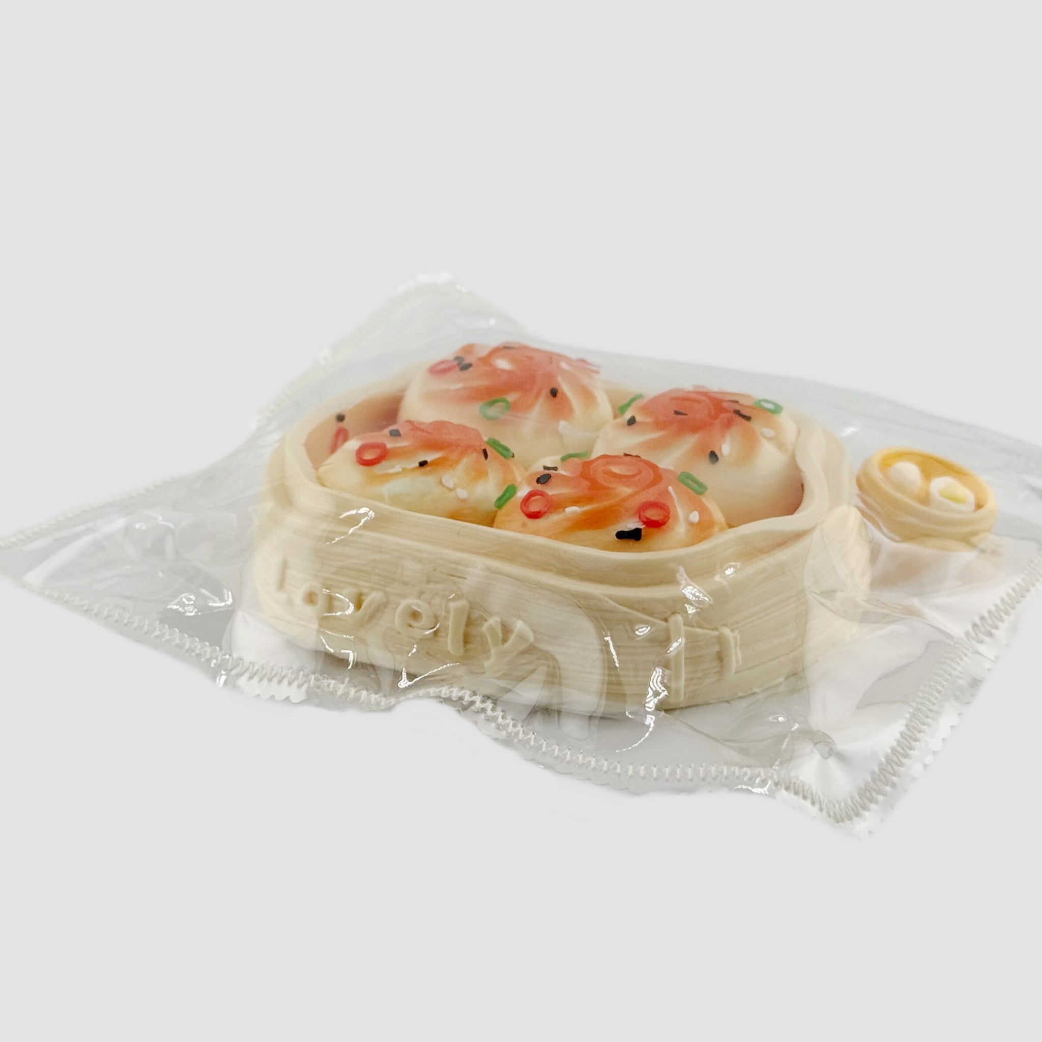 Side view of dumpling squishy toy set in clear packaging